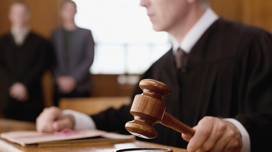 Juez con el mazo de ley en la mano en un juicio oral