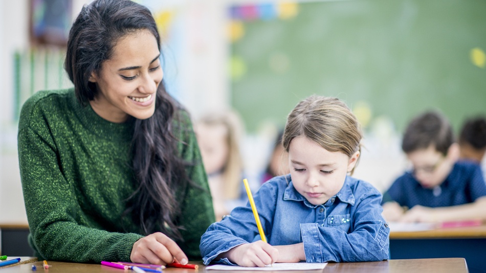 Profesora ayudando a un niño con dislexia